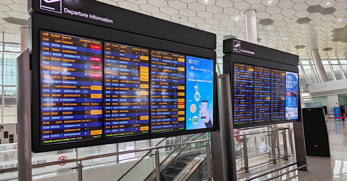 Digital display screens in airport terminals showing real-time flight departure and arrival information.